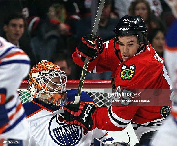 Andrew Shaw of the Chicago Blackhawks tangles with Cam Talbot of the Edmonton Oilers as the puck flys off of Talbots' chest at the United Center on...