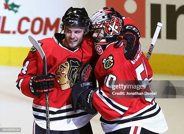 Niklas Hjalmarsson of the Chicago Blackhawks hugs Corey Crawford after Crawford shut out the Edmonton Oilers at the United Center on December 17,...