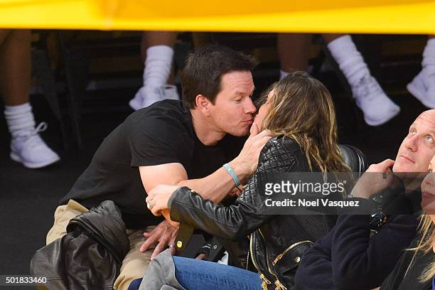 Mark Wahlberg and Rhea Durham kiss their daughter Ella Rae Wahlberg at a basketball game between the Houston Rockets and the Los Angeles Lakers at...