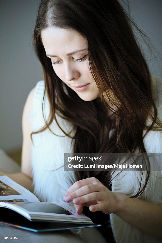 Woman with brown hair reading a book, Copenhagen, Denmark