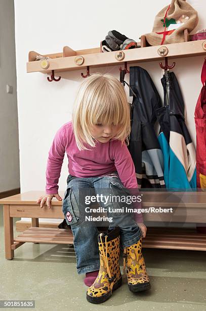 girl pulling on boots, kottgeisering, bavaria, germany, europe - shoes closet 個照片及圖片檔