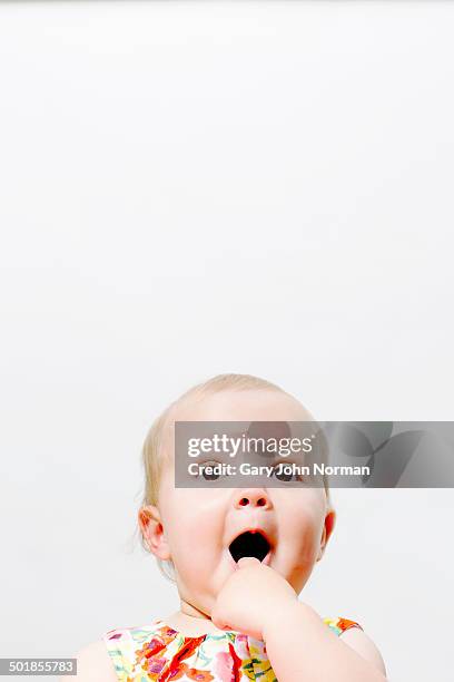 baby looking innocently surprised - 指をくわえる ストックフォトと画像