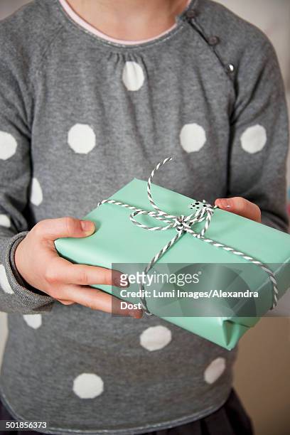 girl on birthday party holding a gift box, munich, bavaria, germany - alexandra dost stock-fotos und bilder