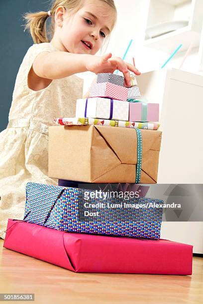 girl on birthday looking at stack of presents, munich, bavaria, germany - alexandra dost stock-fotos und bilder