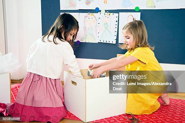 two girls playing in nursery - opbergen stockfoto's en -beelden