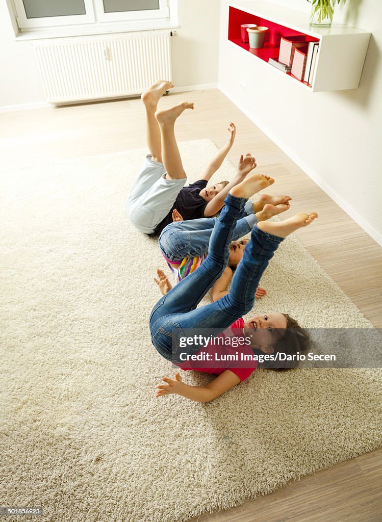 Three children in living room fooling around, Munich, Bavaria, Germany