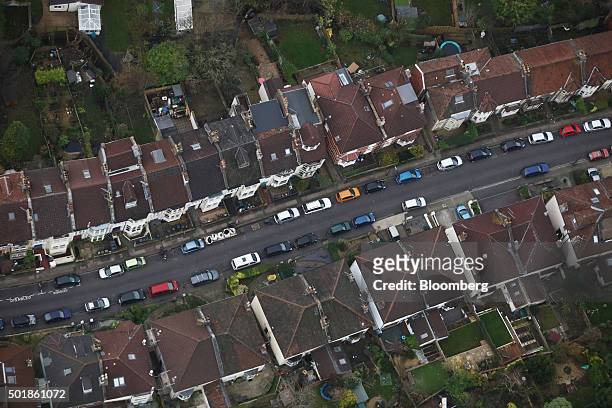 Automobiles stand parked in the street outside residential houses in this aerial photograph taken over Bristol, U.K., on Thursday, Dec. 17, 2015....