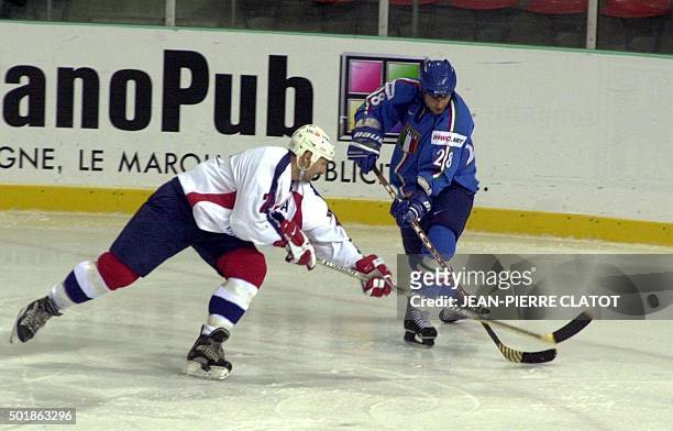 Le Français Denis Perez dispute le palai au joueur italien Lino De Toni, le 10 novembre 2001 dans la patinoire de Grenoble, lors du match de hockey...