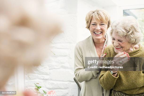 senior woman with daughter, laughing - senior women friends stock pictures, royalty-free photos & images