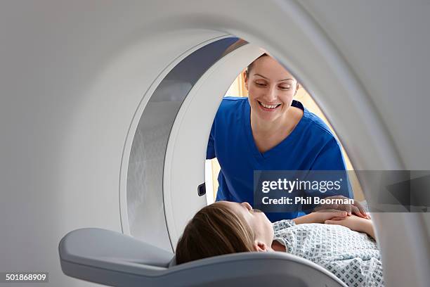 radiographer smiling at girl inside ct scanner - radiographer stock pictures, royalty-free photos & images