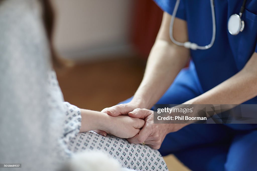 Cropped image of nurse holding patient's hand