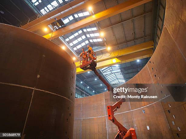 engineers on high lift inspecting marine fabrication used for cable laying - maquinaria de construcción fotografías e imágenes de stock