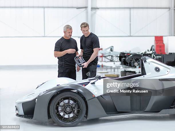 engineers discussing supercar in sports car factory - car engineer stock pictures, royalty-free photos & images