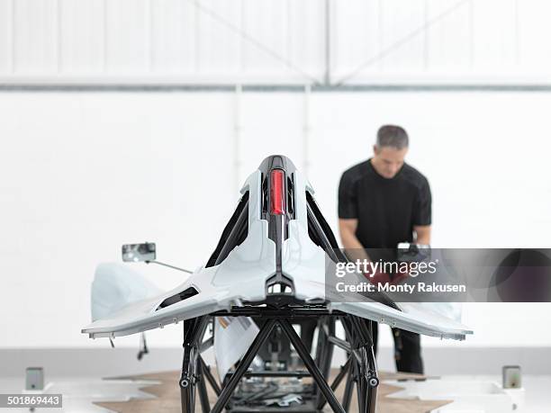 engineer inspecting carbon fibre car body shell in sports car factory - supercar stockfoto's en -beelden