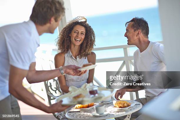 couple having breakfast on beach house balcony - beach house balcony stock pictures, royalty-free photos & images