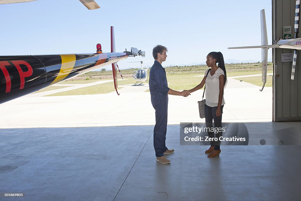 Student pilot shaking hand of woman