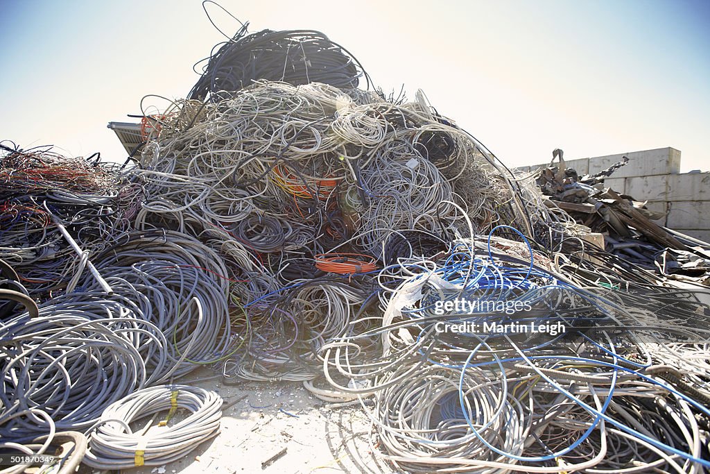 Heap of coiled and tangled cables in scrap metal yard