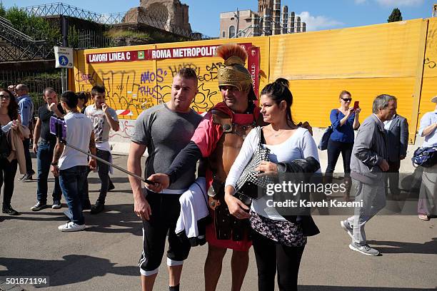 Man dressed as a Gladiator makes a selfie with foreign tourists outside the Colloseum on October 15, 2015 in Rome, Italy.