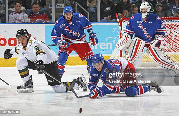 Jacob Cascagnette of the Kitchener Rangers clears a puck away from Kole Sherwood of the London Knights during an OHL game at Budweiser Gardens on...