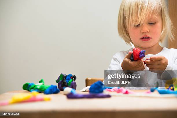 three year old boy playing with modeling clay - clay stock-fotos und bilder