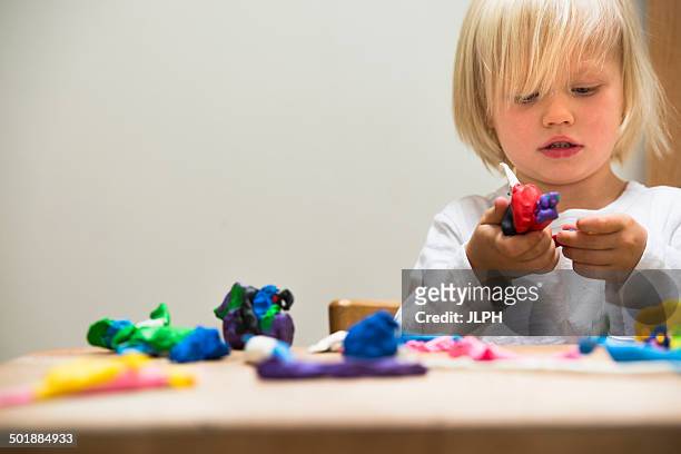three year old boy playing with modeling clay - clay foto e immagini stock