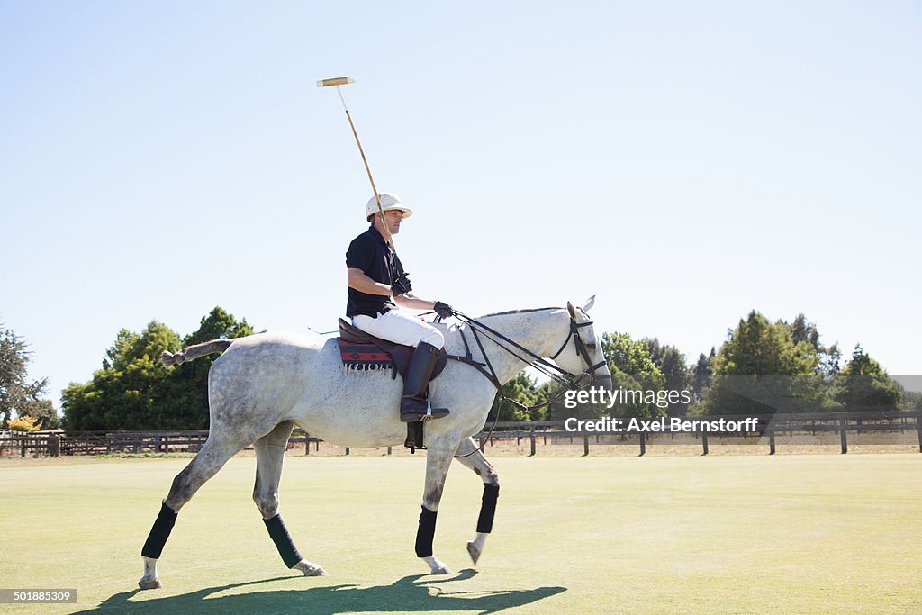 Mid adult man playing polo