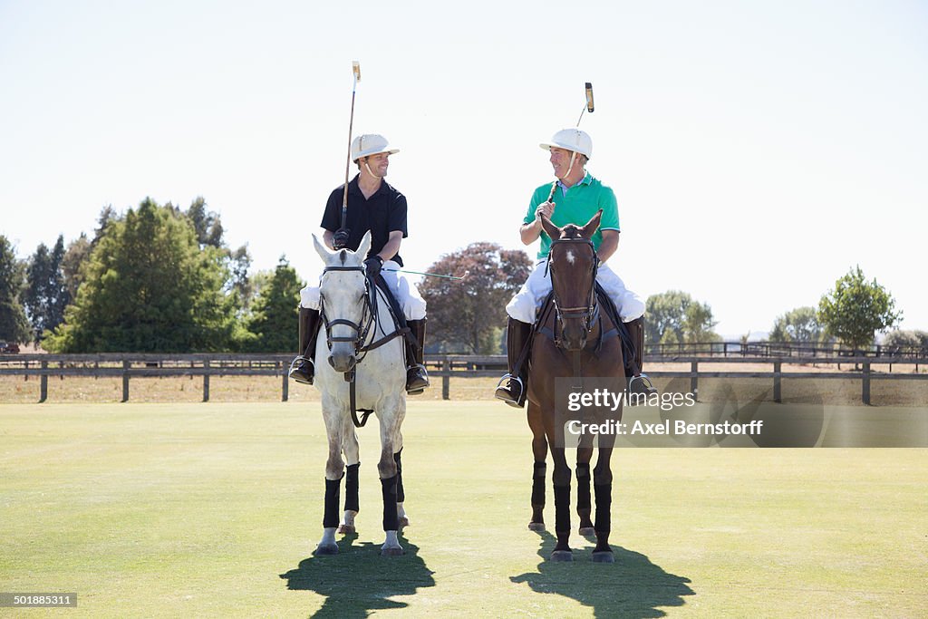 Two adult men playing polo