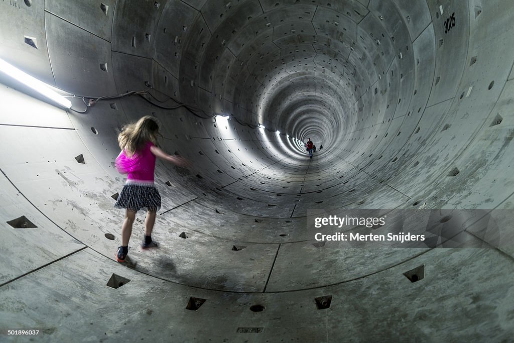 Girl running through subway pipe