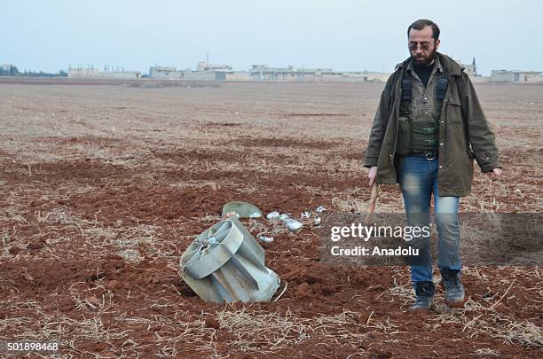 Syrian man picks up alleged shrapnels of a cluster bombs from the ground after the war crafts belonging to the Russian army attacked front line...