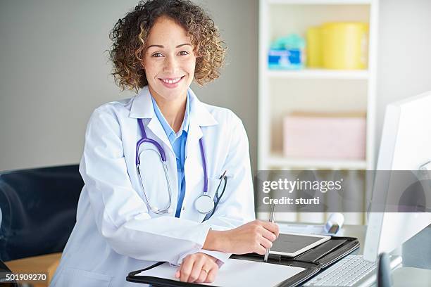 proud female doctor sitting at her desk - electronic medical record stock pictures, royalty-free photos & images