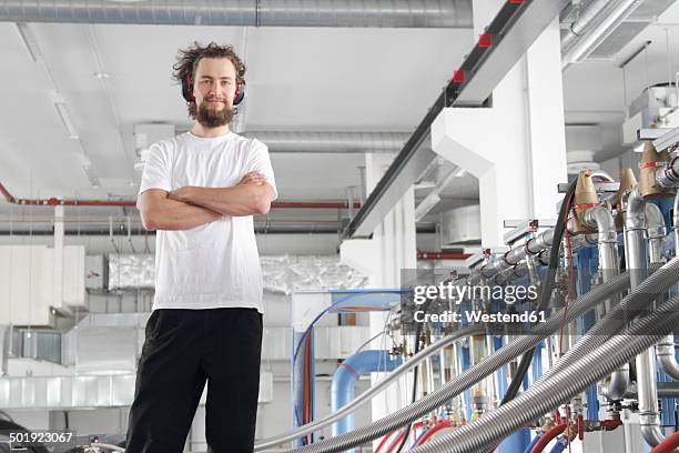 technician at a machine in a factory hall - industrial hose stockfoto's en -beelden