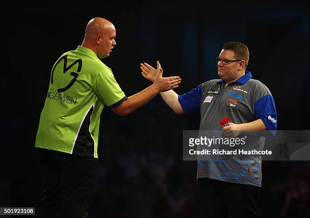 Michael van Gerwen consoles Rene Eidams after narrowly beating Eidams in their first round match on day two of the 2016 William Hill PDC World Darts...
