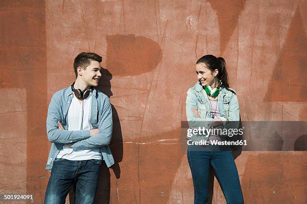 teenage boy and teenage girl communicating - boy headphones stock-fotos und bilder