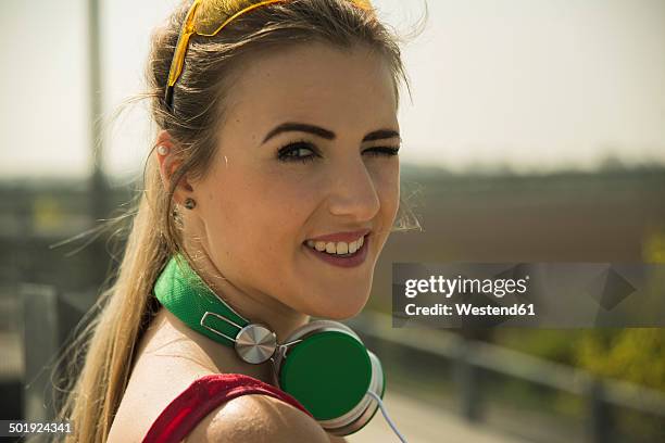 smiling blond young woman with headphones - head turner stock pictures, royalty-free photos & images