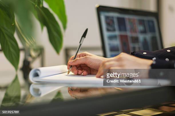 young woman writing on notepad, partial view - balpen stockfoto's en -beelden