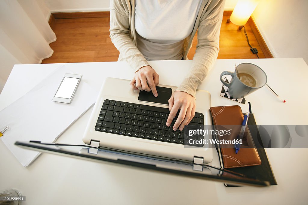 Woman working at modern home office, partial view