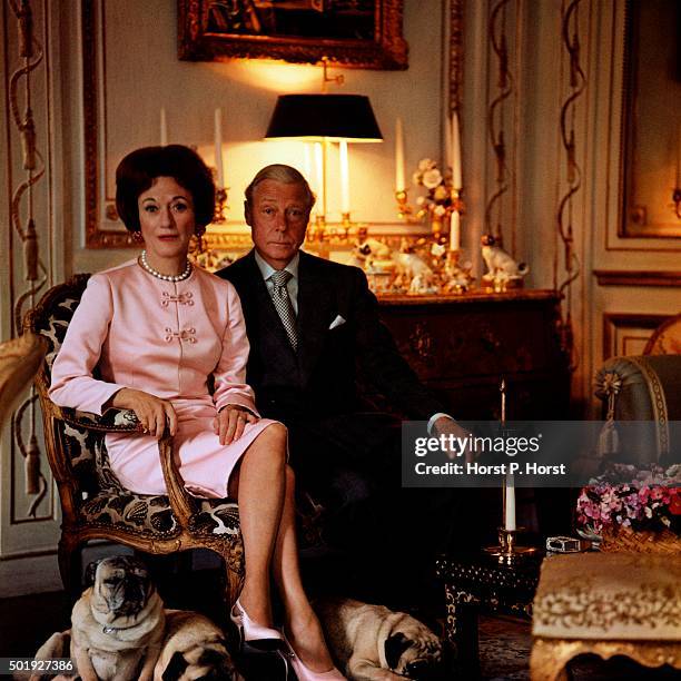 The Duke and Duchess of Windsor, sitting in the drawing room of their Paris home, with their four Pug dogs at their feet.