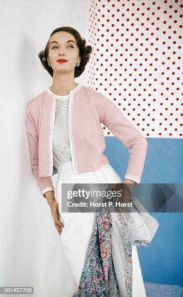 Model wearing pink sweater over confetti-print cotton blouse by Evelyn Gates, jewelry by David Webb.