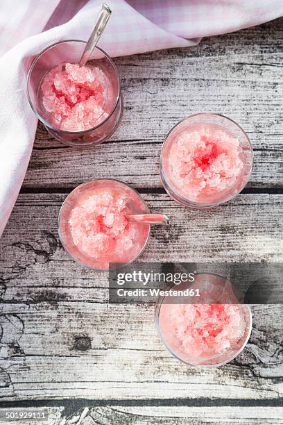 four glasses of rhubarb granita on wooden ground, view from above - sorbetto stockfoto's en -beelden