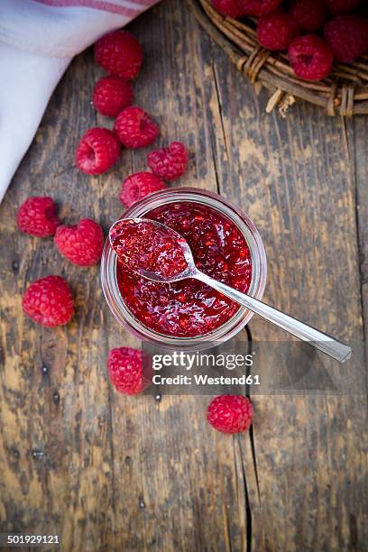 glass of raspberry jam and raspberries on wooden table, elevated view - raspberry jam stock pictures, royalty-free photos & images