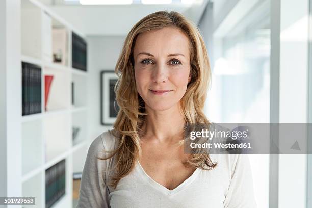 portrait of woman in her bright modern home - blonde photos et images de collection