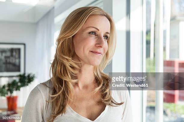 portrait of happy woman in her bright modern home - sideways glance stock pictures, royalty-free photos & images