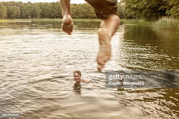 young man jumping in quarry pond - lower saxony stock pictures, royalty-free photos & images