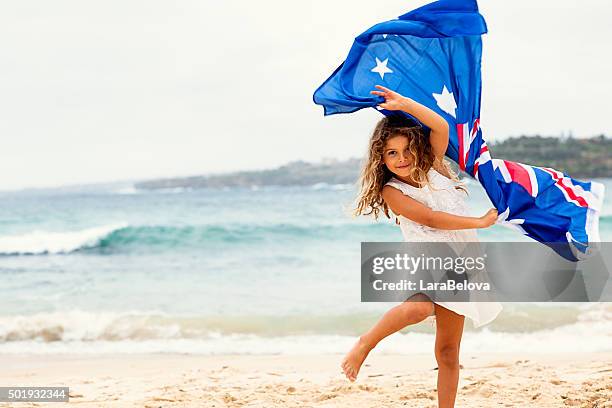 escuela preescolar chica con bandera australiana en la playa - día de australia fotografías e imágenes de stock