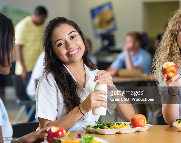 cute hispanic teenager having lunch with friends in school cafeteria - cute teens stock pictures, royalty-free photos & images