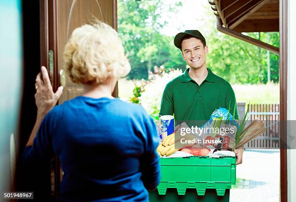 delivery man with groceries - home delivery stock pictures, royalty-free photos & images