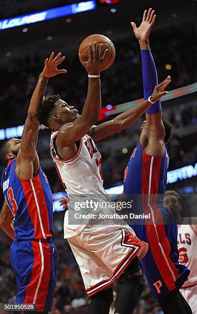 Jimmy Butler of the Chicago Bulls goes up for a shot between Marcus Morris and Andre Drummond of the Detroit Pistons on his way to a game-high 43...
