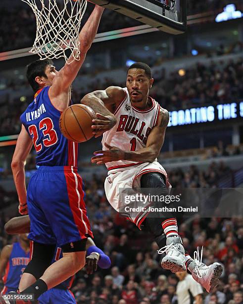 Derrick Rose of the Chicago Bulls passes around Ersan Ilyasova of the Detroit Pistons at the United Center on December 18, 2015 in Chicago, Illinois....