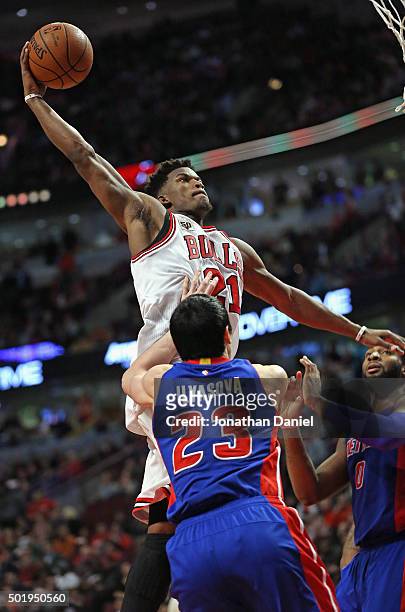Jimmy Butler of the Chicago Bulls goes up for dunk over Ersan Ilyasova and Andre Drummond of the Detroit Pistons on his way to a game-high 43 points...