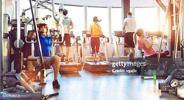 group of people exercise in a gym. - gym stockfoto's en -beelden